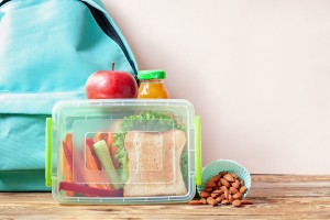 学校午餐盒，桌上有三明治、蔬菜、果汁和杏仁。健康饮食习惯的概念。